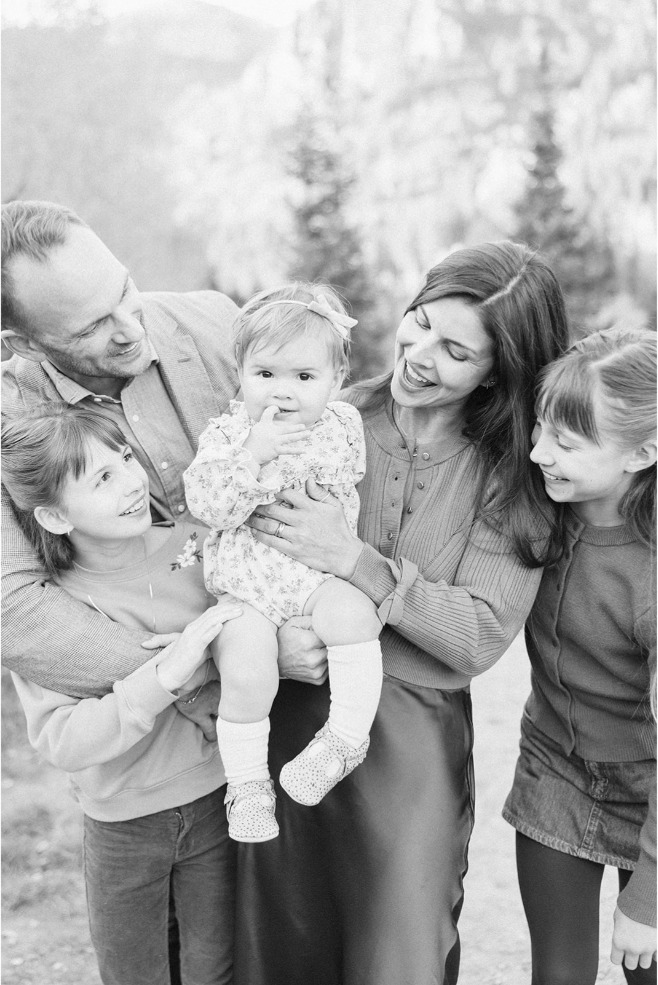 Black and white close-up of a family snuggled together around their baby