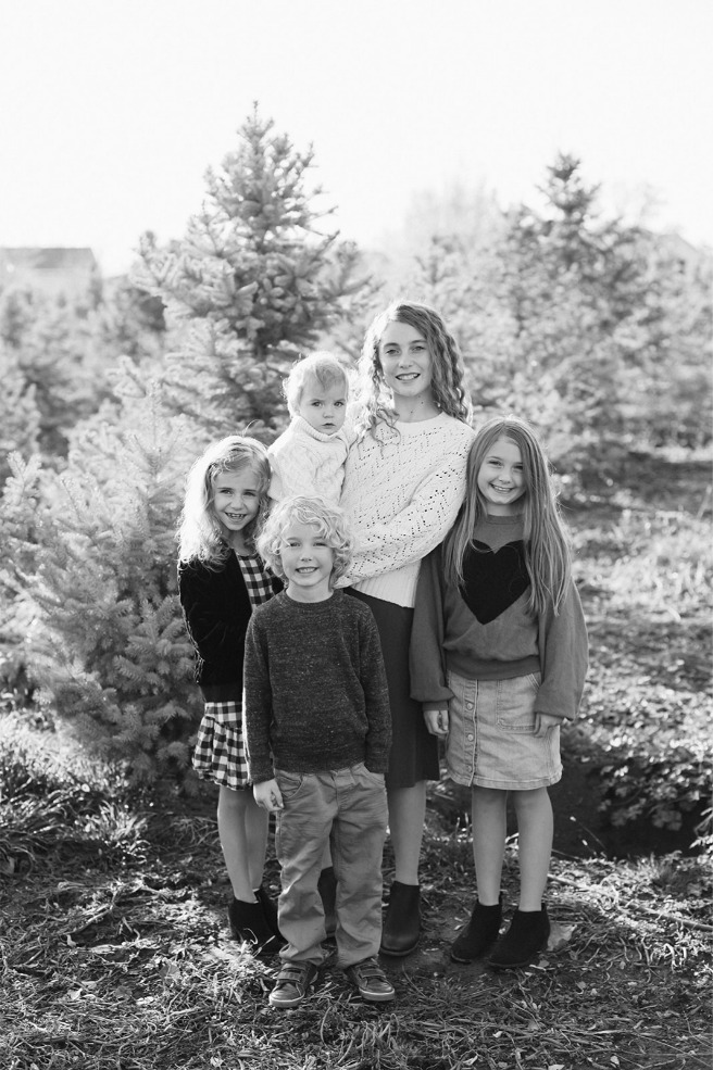 Black and white portrait of siblings at a Christmas tree farm
