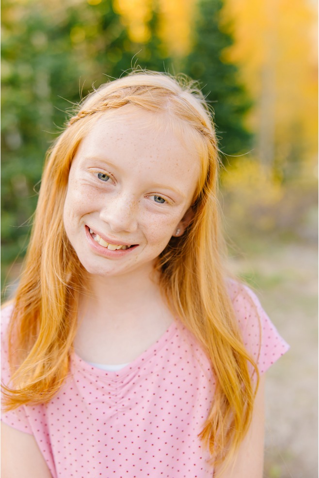Close-up portrait of a girl in a pink polka-dot dress on a fall canyon trail