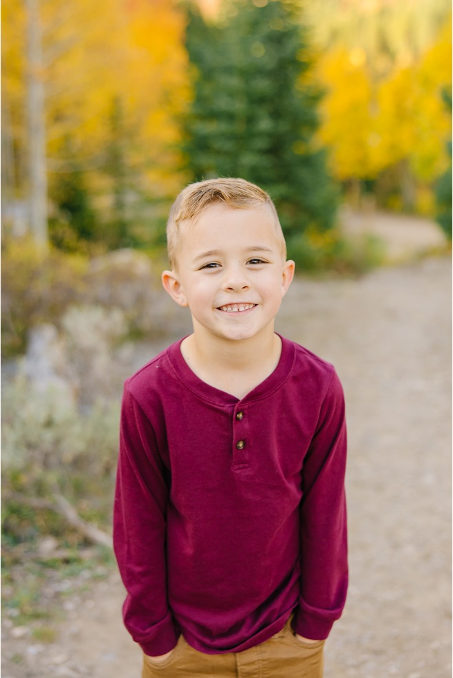 Boy in a maroon henley with hands in his pockets during Utah fall family photos